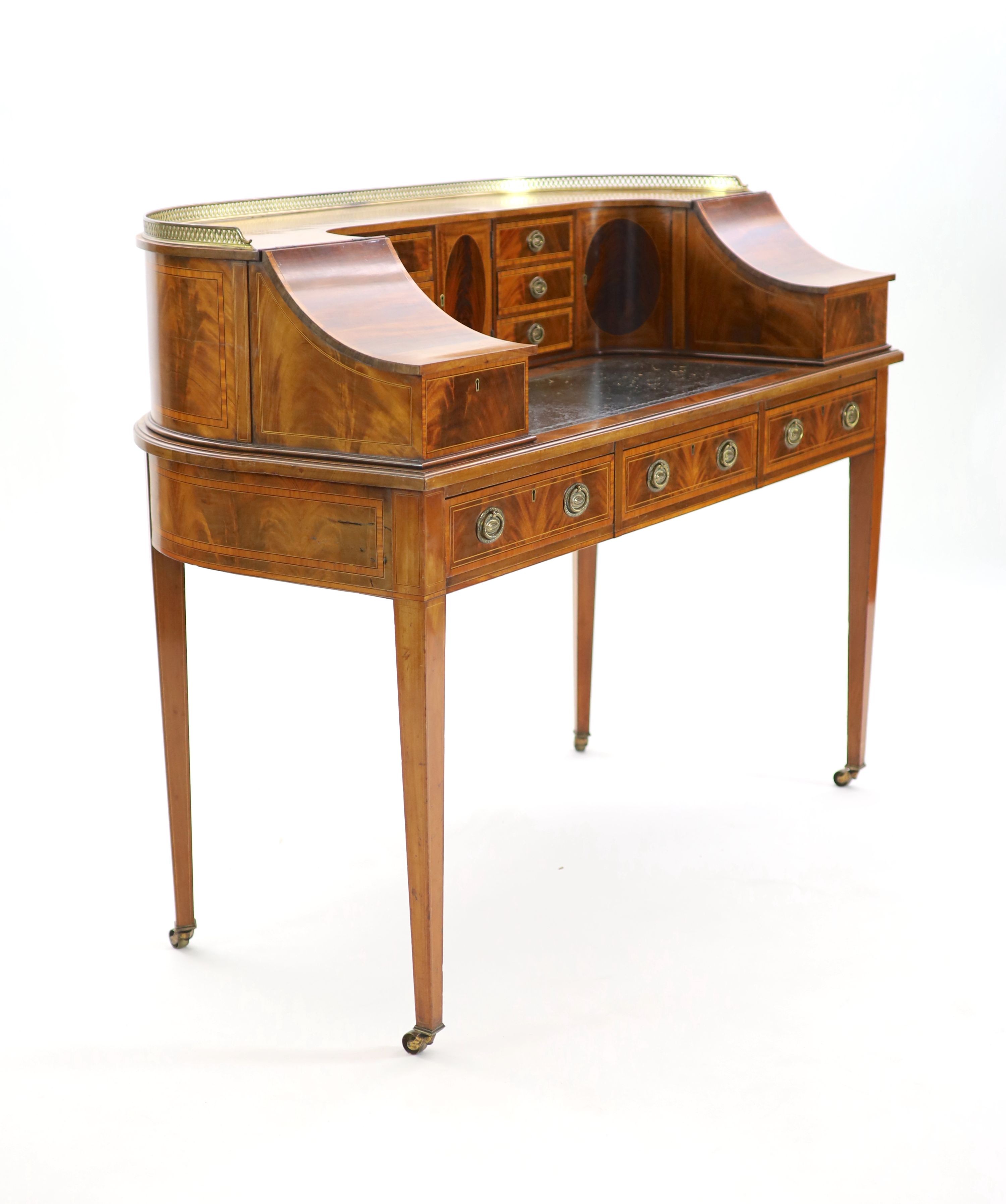 An Edwardian Sheraton revival satinwood banded mahogany Carlton House desk, W.138cm D.65cm H.104cm